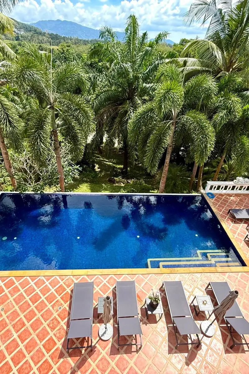 Pool deck with sun loungers and tropical garden surround