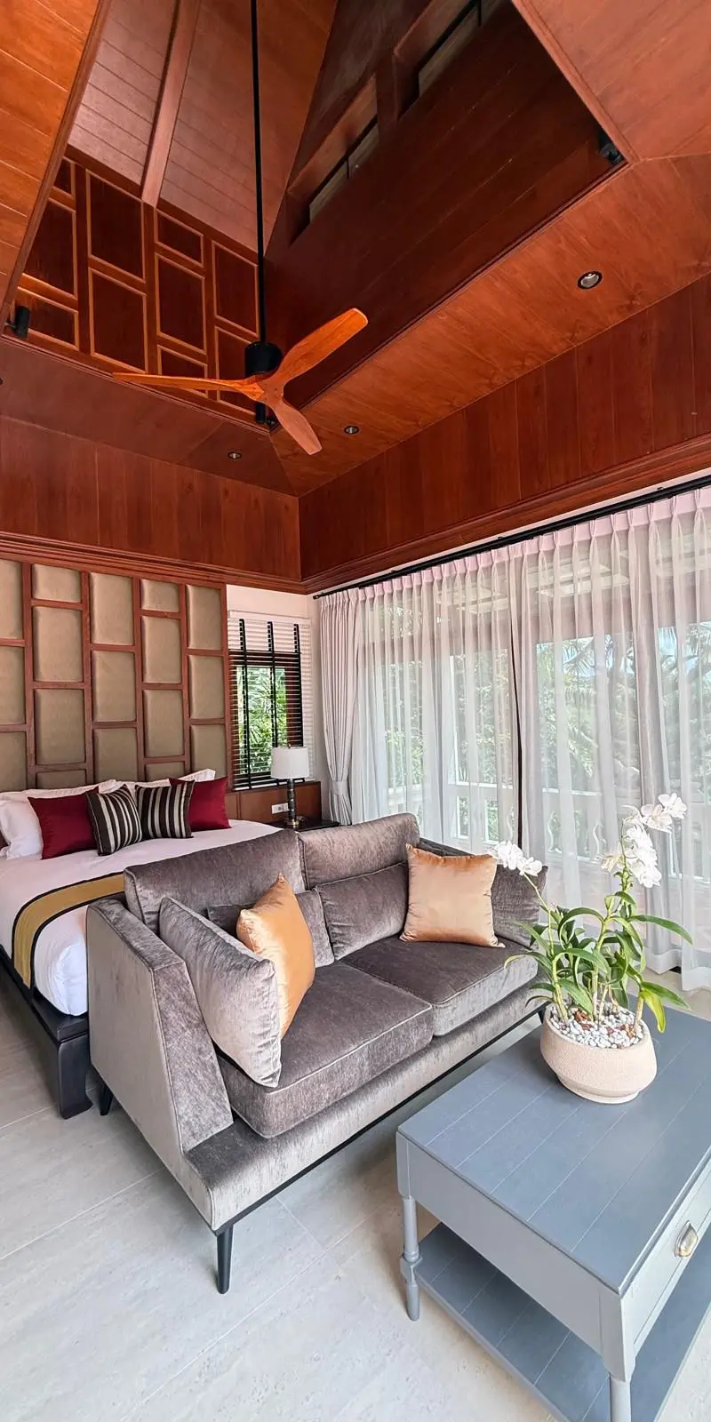 Guest bedroom with vaulted Thai ceiling and grey velvet loveseat