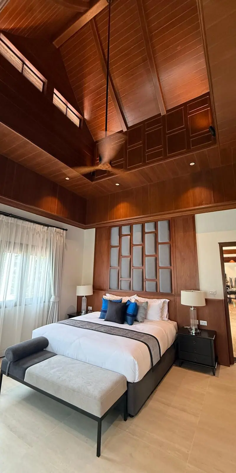 Guest bedroom from the foot of the bed — vaulted ceiling, mirror wall