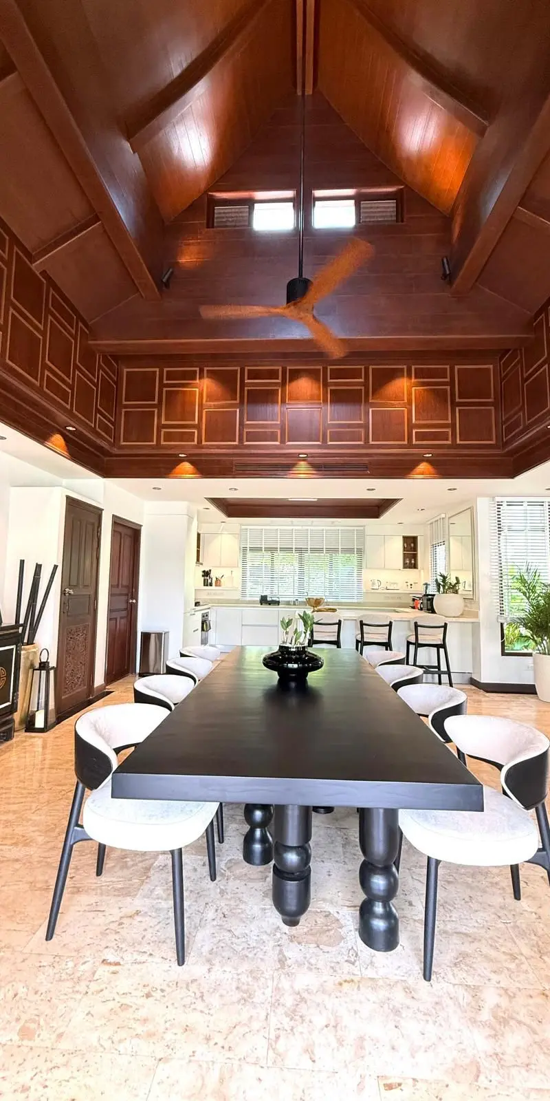 Dining room with long dark-wood table under cathedral Thai ceiling