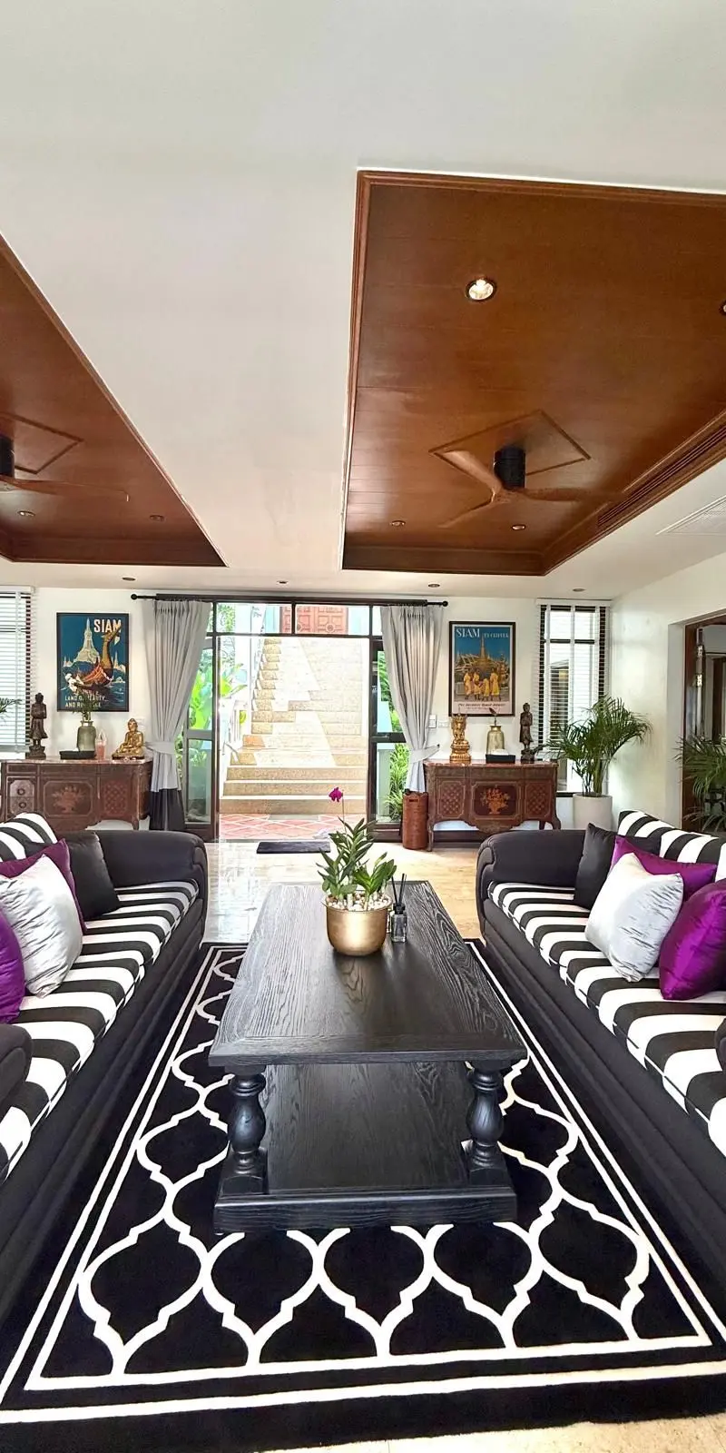 Main living room from the entry — open to the terrace, Thai art collection