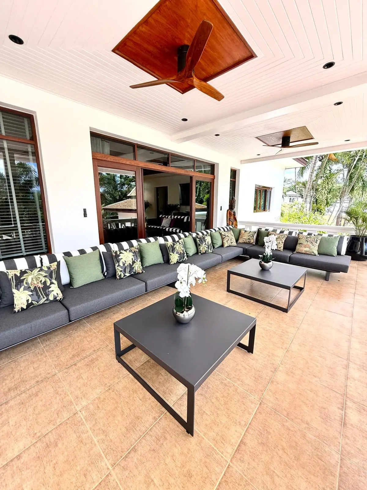 Covered terrace with U-shape sectional sofa and large ceiling fan