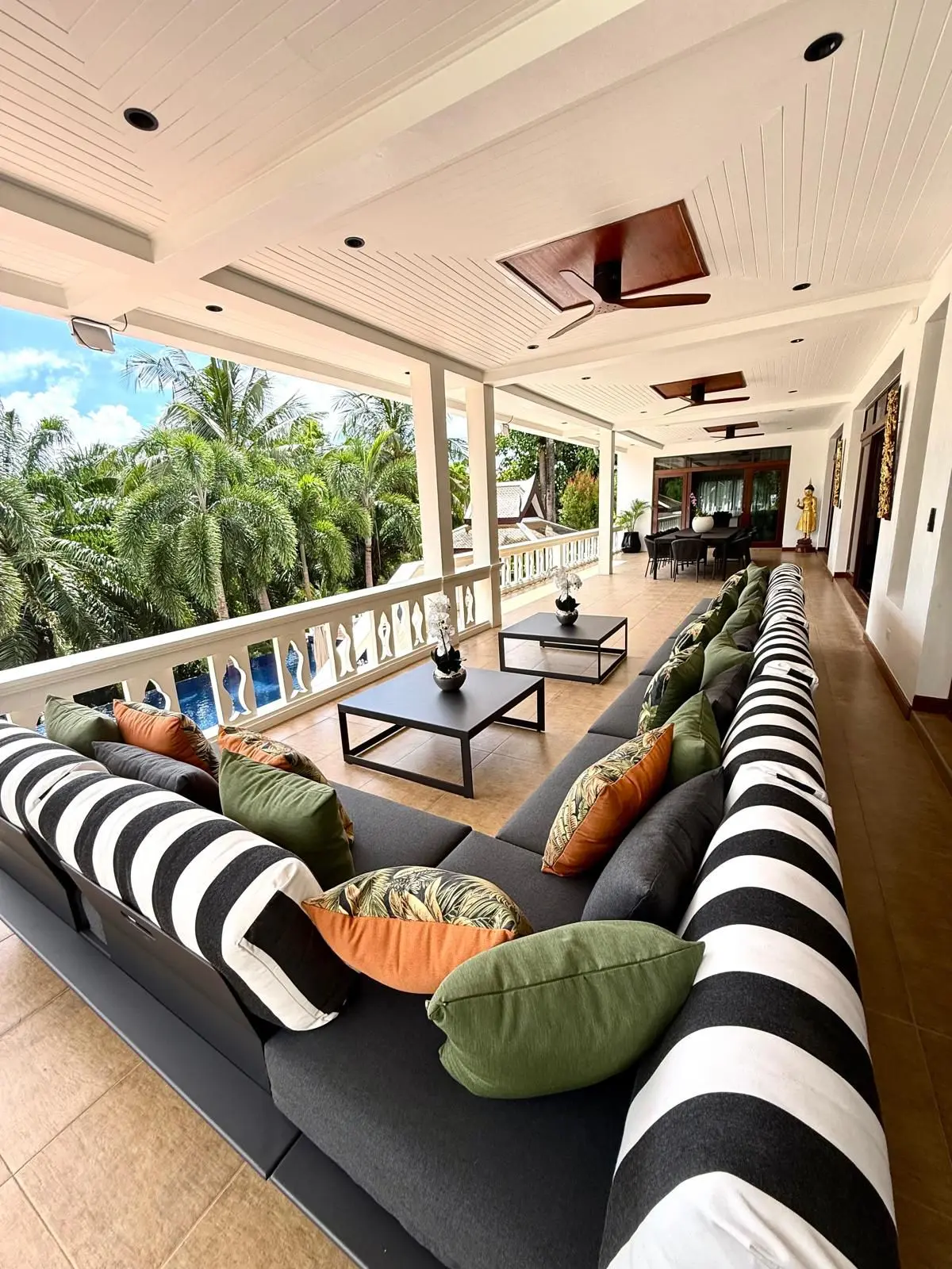 Long covered terrace with sectional lounge seating along the balustrade