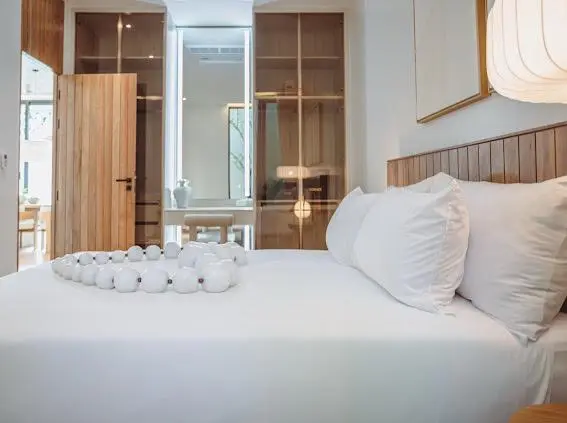 Master bedroom with wood-slat headboard and walk-in closet beyond