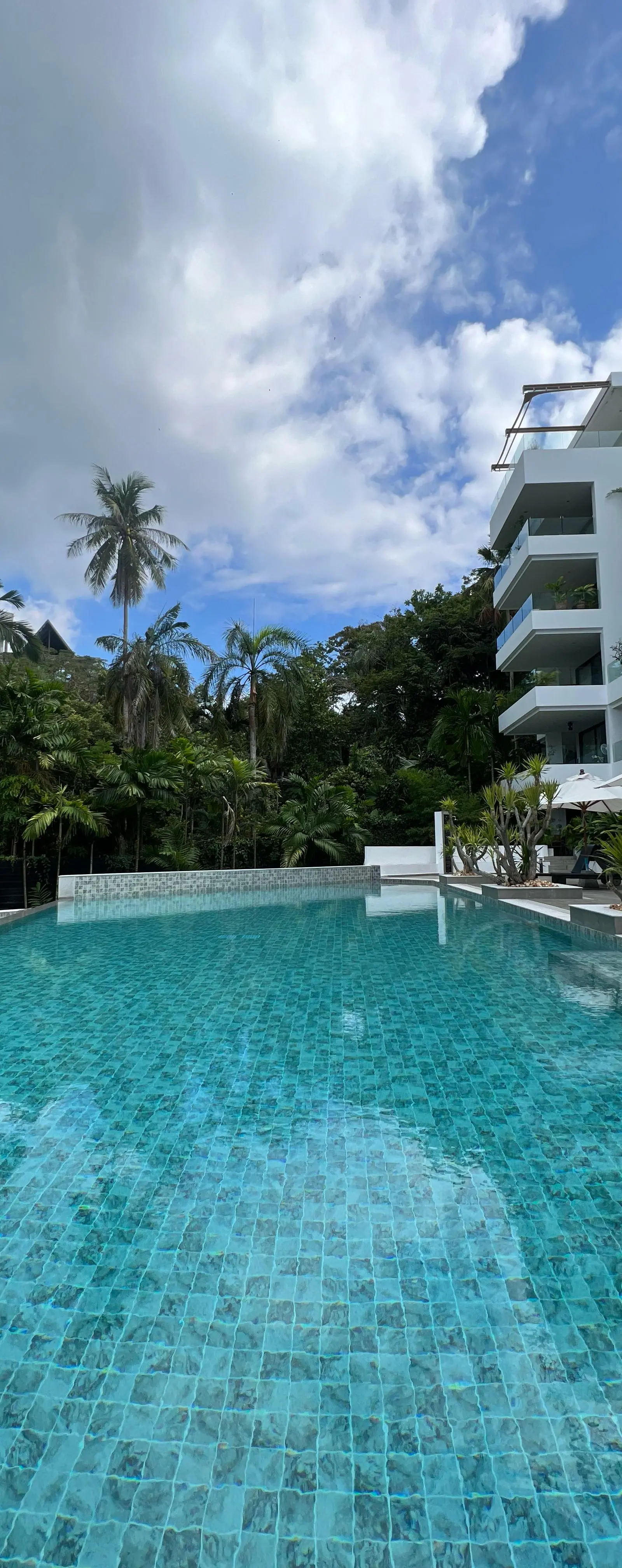 Central pool of Sansuri with sun terrace and residential building