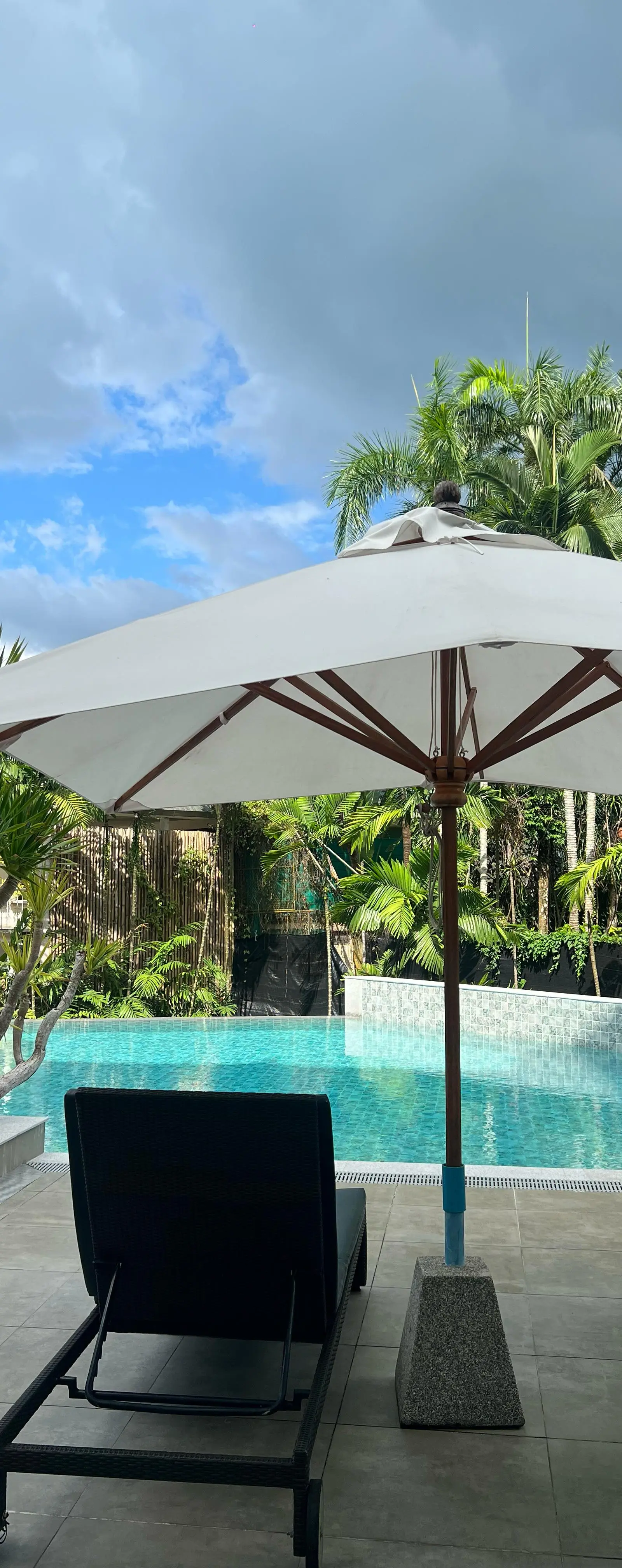 Pool sunbeds under shaded umbrella