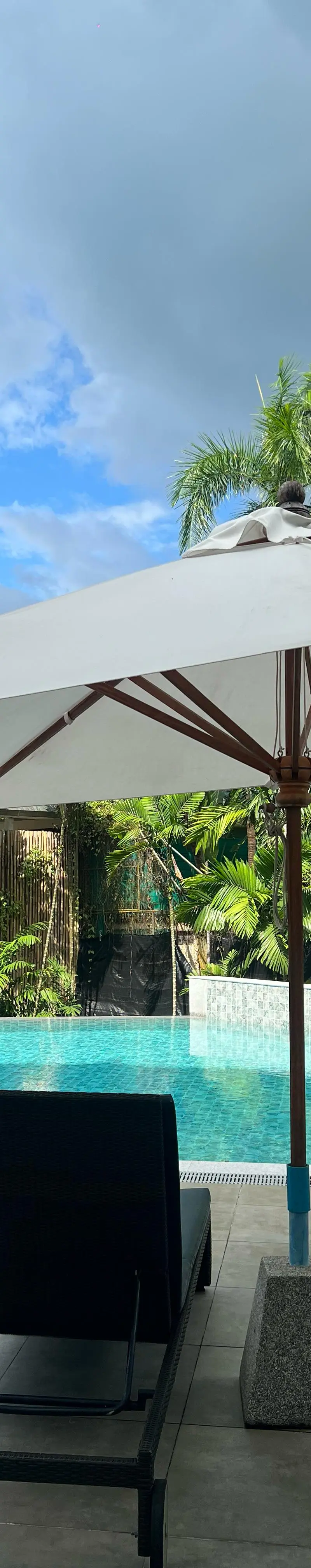 Pool sunbeds under shaded umbrella