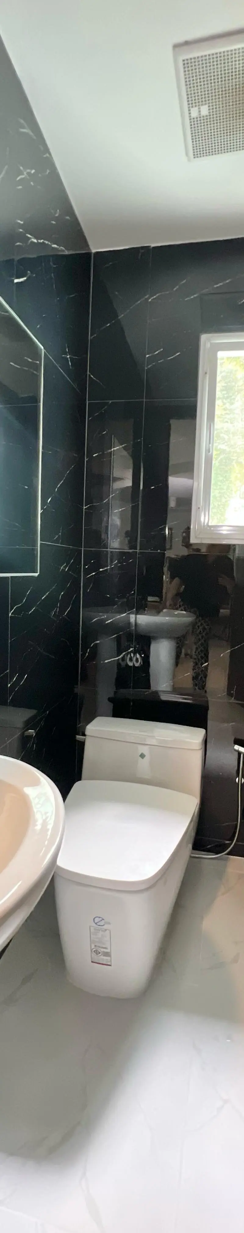 Powder room in dark marble with twin windows