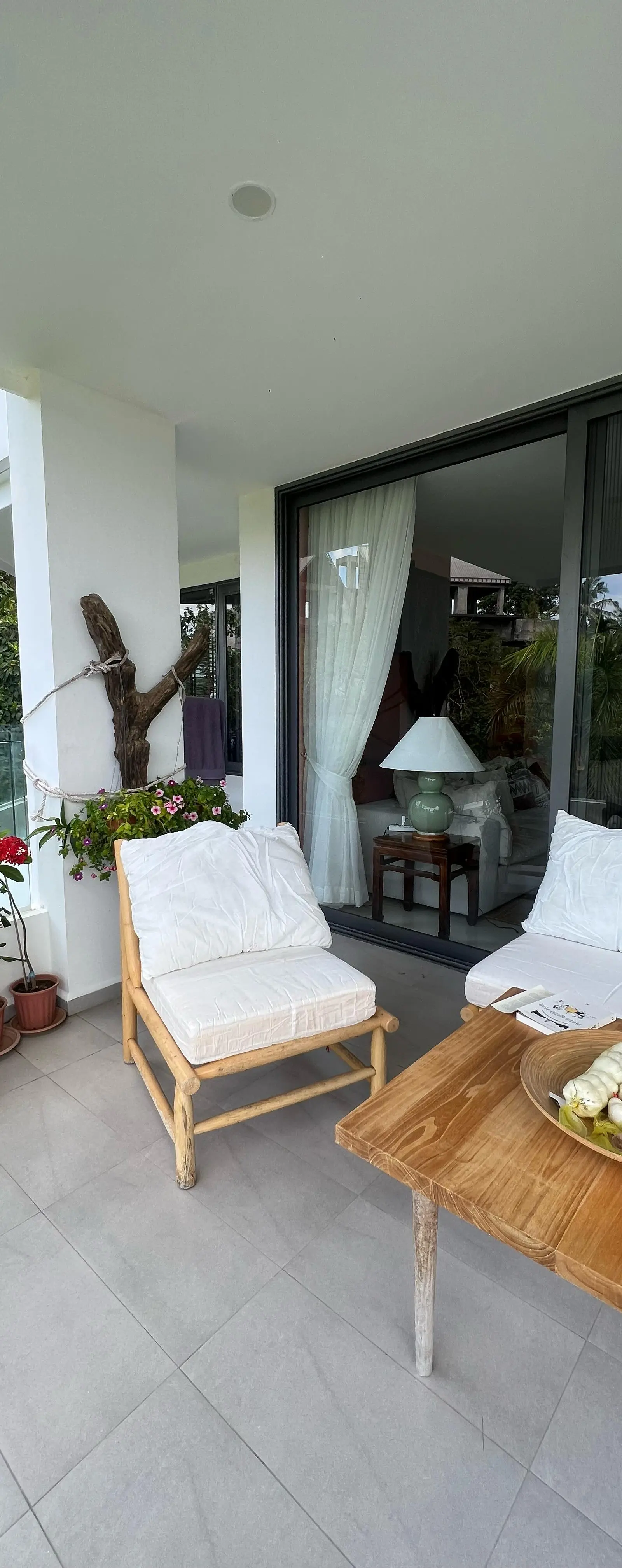 Outdoor terrace with sectional sofa, teak coffee table and flowering plants