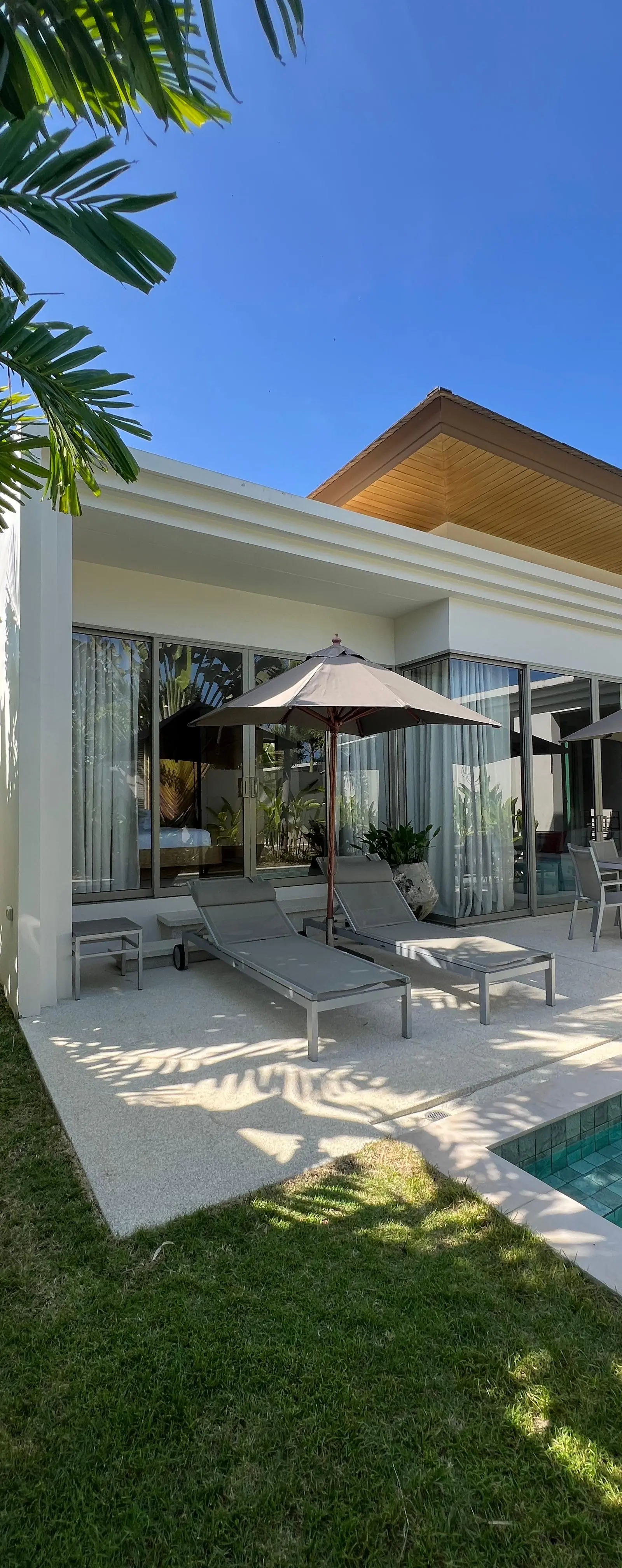 Villa exterior with pool, sun loungers and umbrella