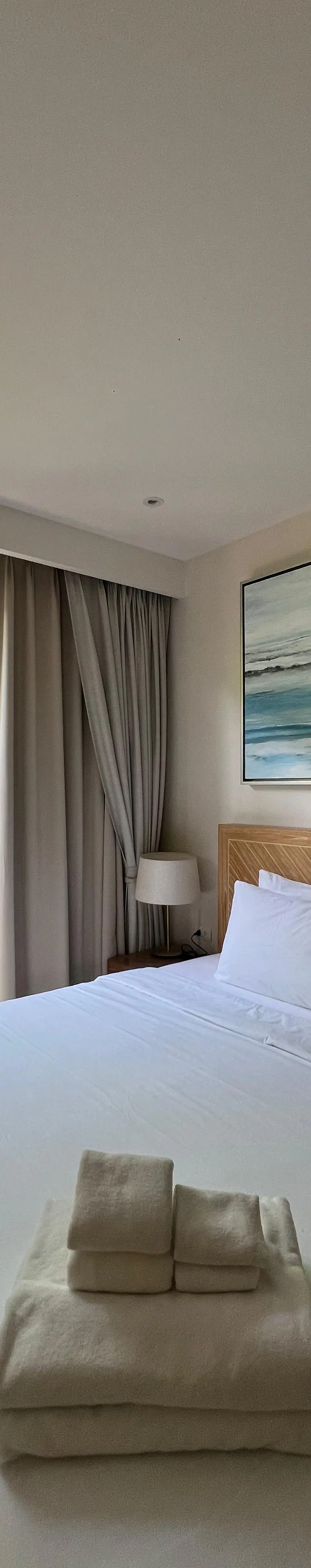 Guest bedroom with framed ocean wave canvas above the bed