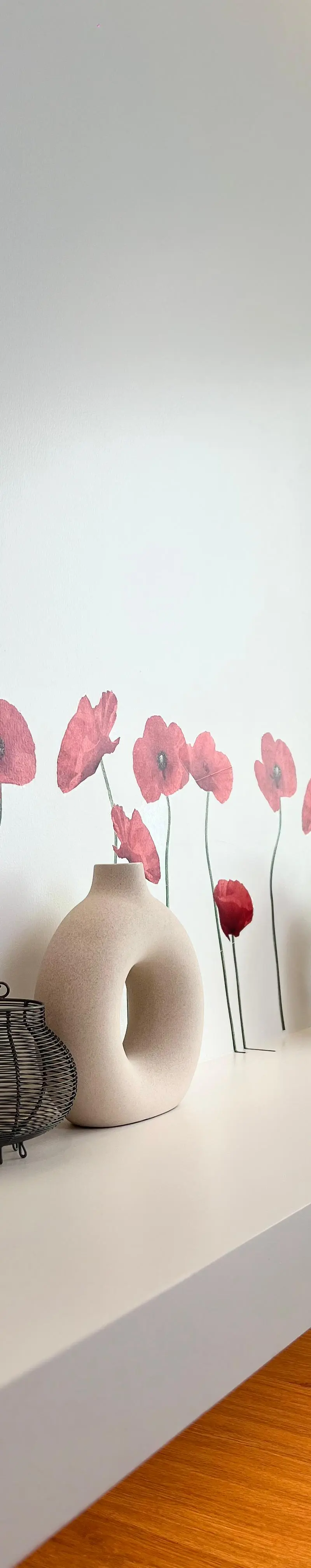 Hallway shelf with poppy wall decals and trio of donut-shape vases