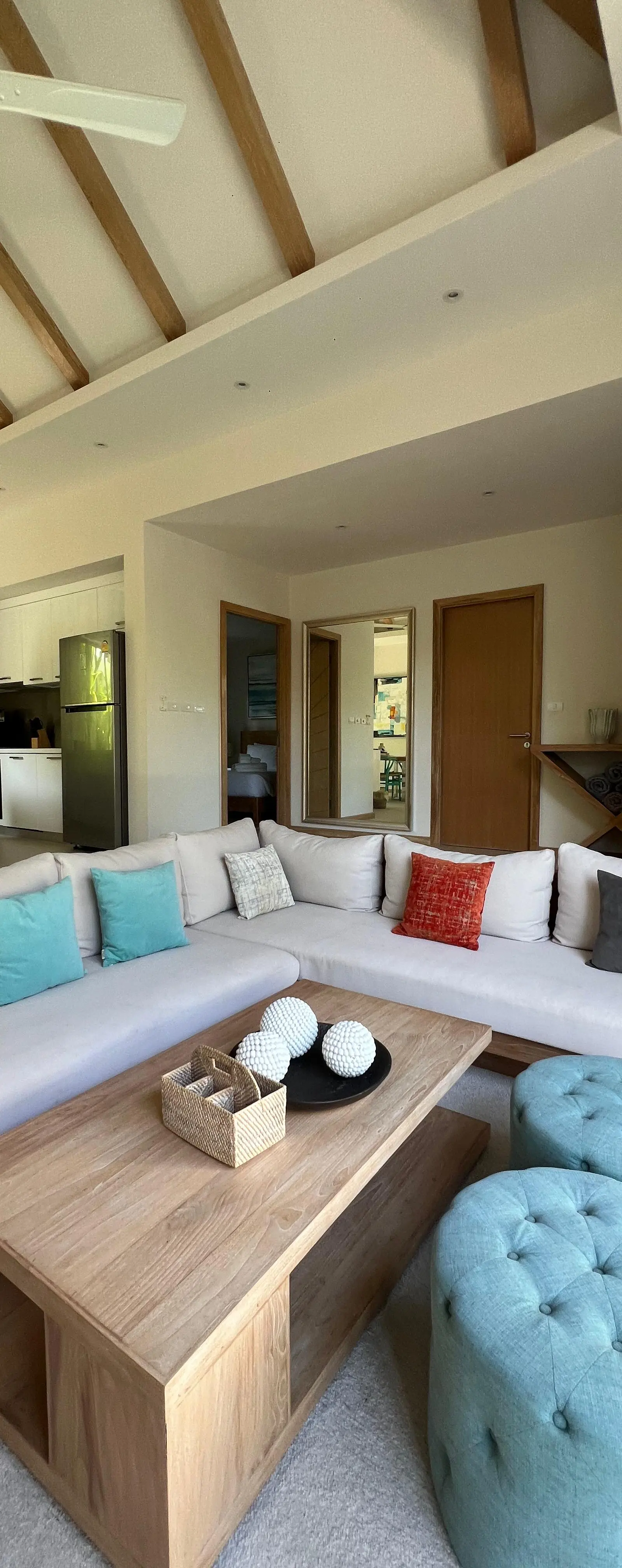 Main living room under vaulted exposed-beam ceiling, with sectional sofa