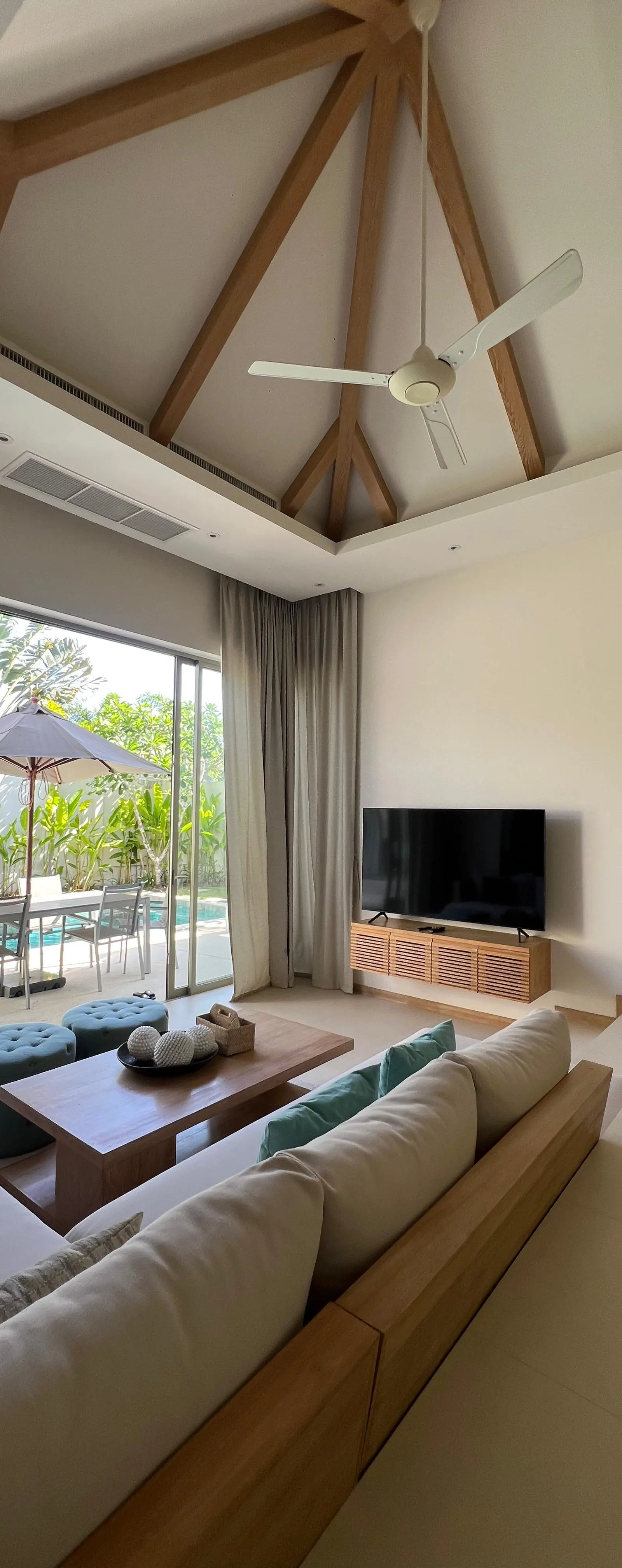 Living room opening onto the pool deck through full-height sliding glazing