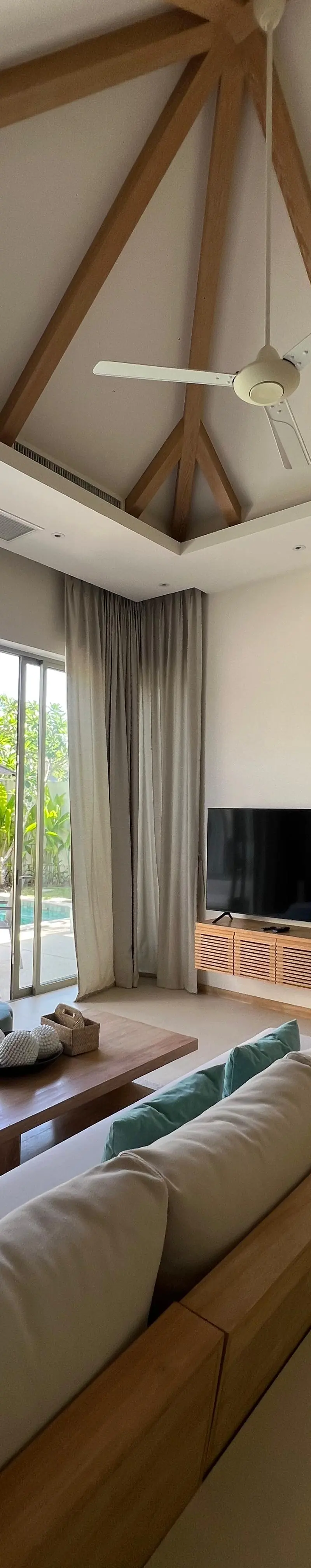 Living room opening onto the pool deck through full-height sliding glazing